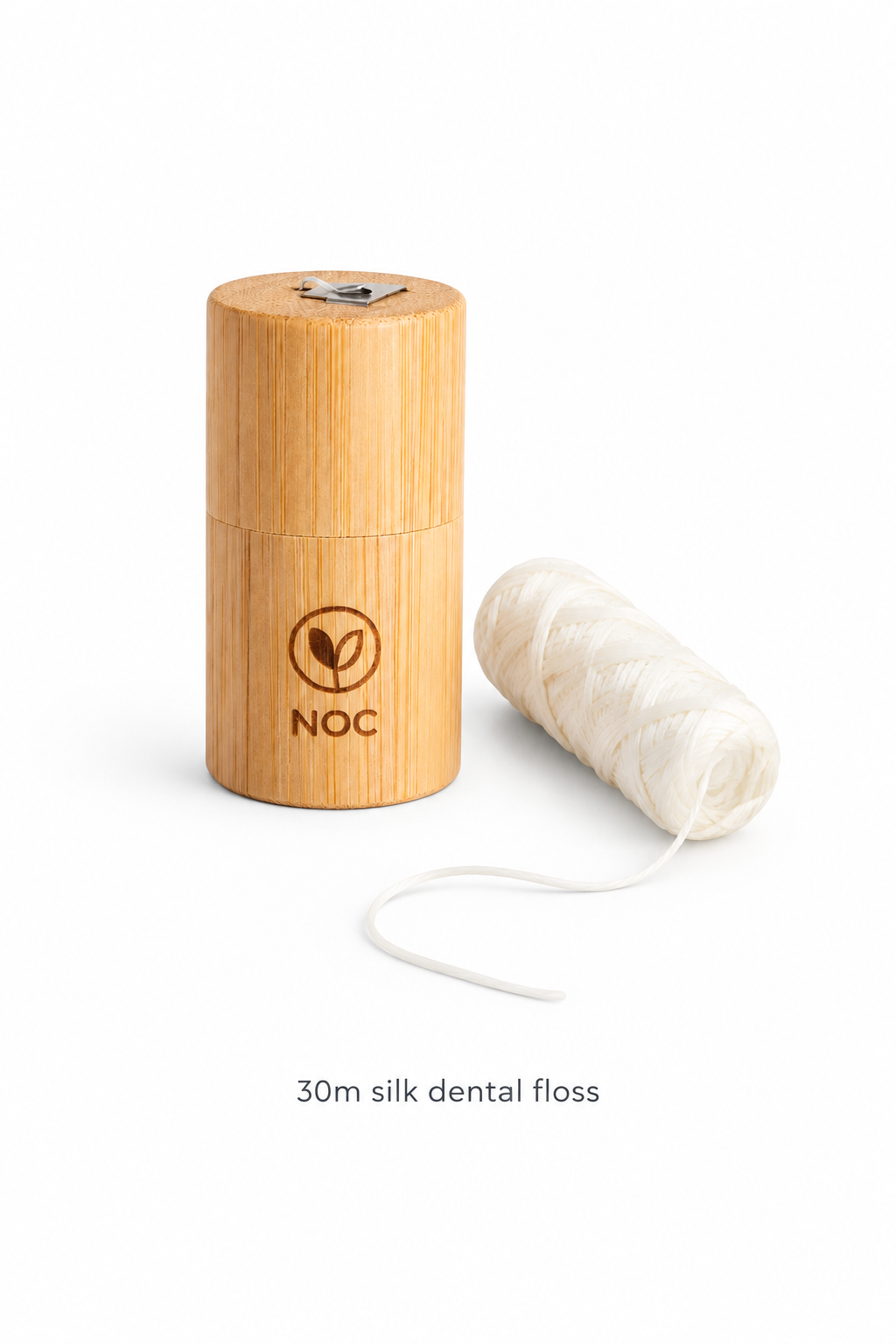 NOC bamboo floss holder beside a silk floss refill and loose thread, labelled 30m silk dental floss.